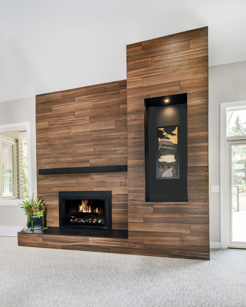 Sleek and contemporary fireplace remodel with porcelain tiles and industrial touches in Littleton by Denver Design Group