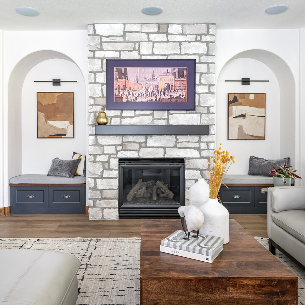 Castle Rock remodel by Denver Design Group features a great room fireplace wall flanked by arched coves that created architectural interest and dimension to the space, illustrating 2025 design trends