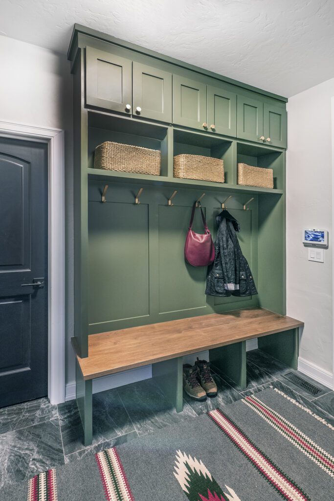 Declutter with modern storage solutions by Denver Design Group include custom built-in hooks, cubbies, and benches in mudrooms, combining functionality with style