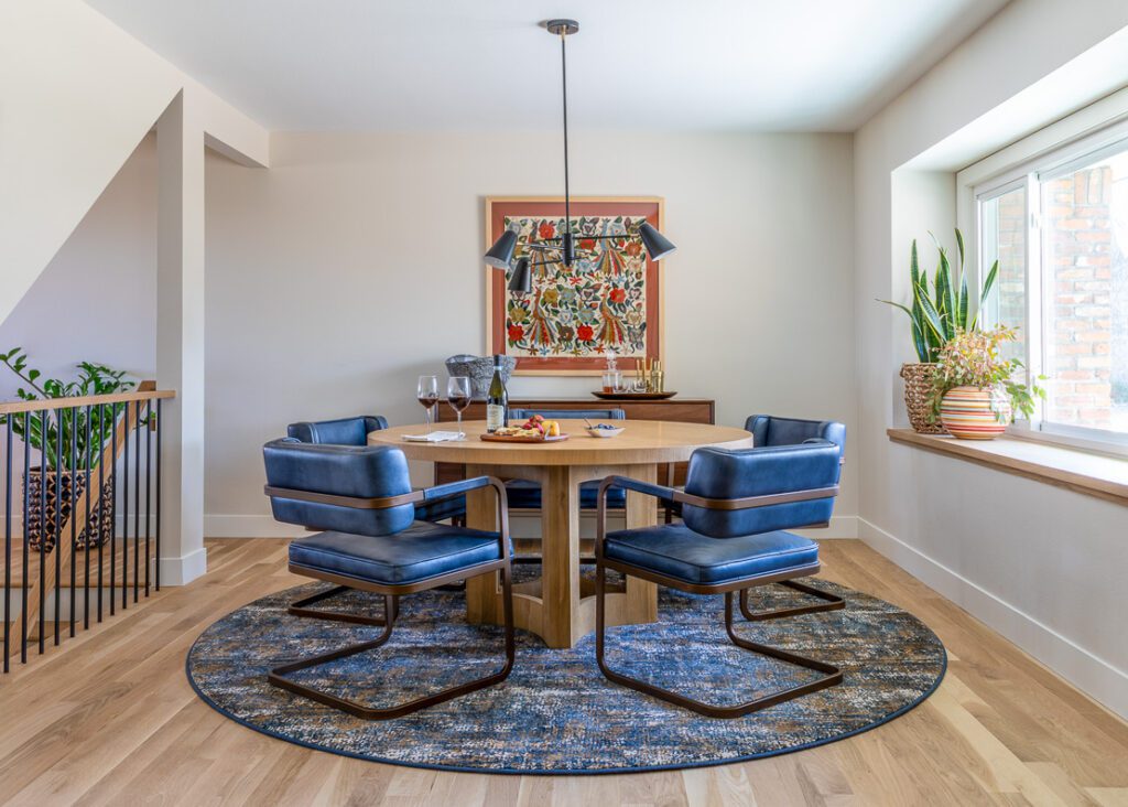 Bright and inviting dining room with curated furnishings, modern lighting, and classic contemporary style in Littleton home remodel project by Denver Design Group