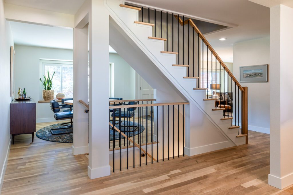 Updated staircase with round balusters and wood treads in a contemporary Littleton home remodel by Denver Design Group