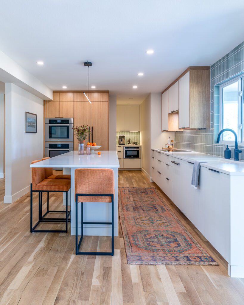 Custom kitchen with Fireclay tile backsplash in soft sage green and sleek built-in appliances in Littleton remodel by Denver Design Group