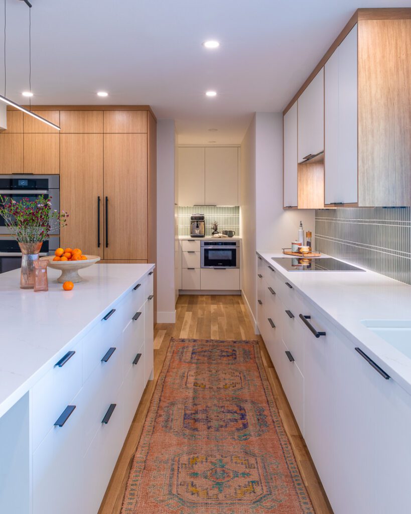 Modern kitchen remodel in Littleton with large island and sage green tile backsplash by Denver Design Group