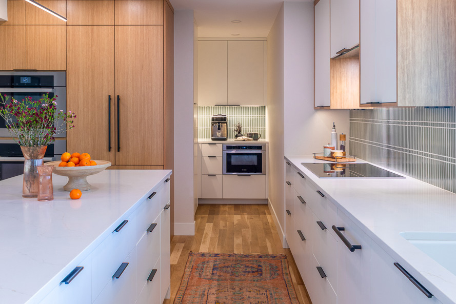 Modern kitchen remodel in Littleton with large island and sage green tile backsplash by Denver Design Group