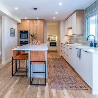 Modern kitchen remodel in Littleton featuring expanded layout, large island, and sage green tile backsplash by Denver Design Group
