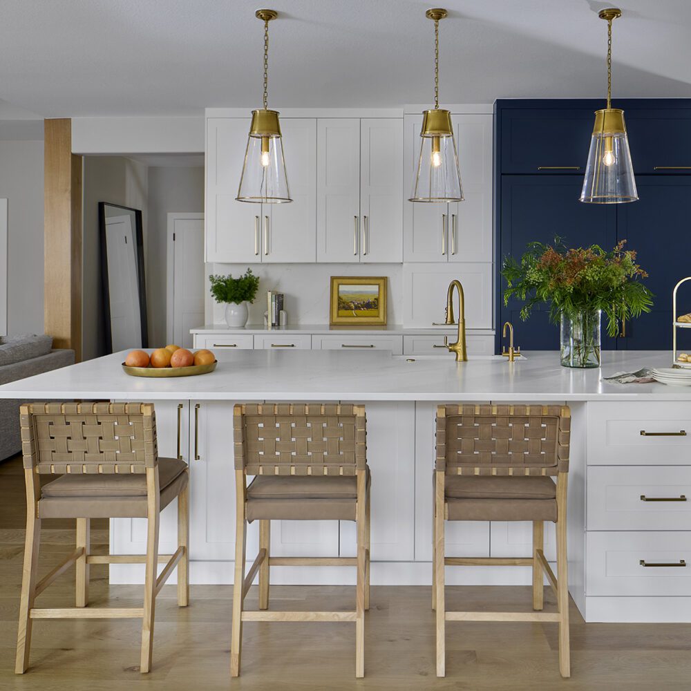 Open-concept kitchen and dining space with natural light and storage in Littleton home remodel by Denver Design Group