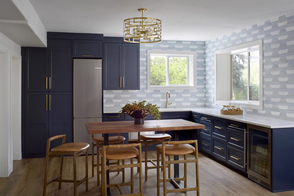 Basement secondary kitchen with curated tile and custom cabinetry, custom dining room table and contemporary seating in whole house remodel in Littleton