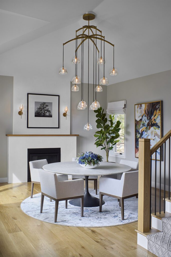 Dining room redesign with fireplace focal point and modern statement chandelier in Littleton remodel by Denver Design Group