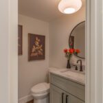 Refined powder room with upgraded materials and cohesive color palette designed to complement main floor remodel