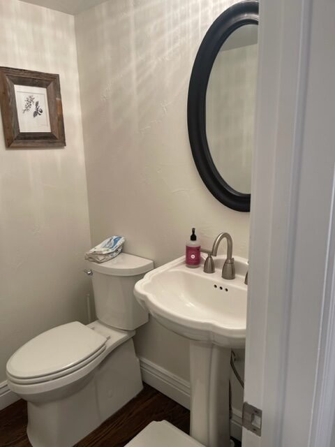 Before photo of dated utilitarian powder room with basic finishes before Denver Design Group remodel
