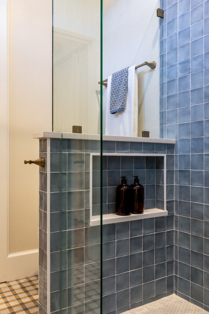 Blue tile shower with built-in niche in child's bathroom Park Hill Denver remodel by Denver Design Group