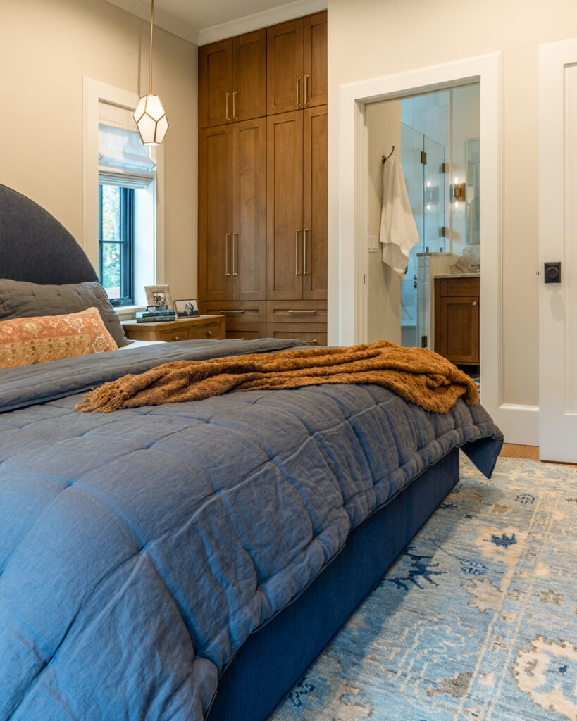Primary suite with built-in walnut closet system and ensuite bathroom in Park Hill Denver whole home remodel by Denver Design Group