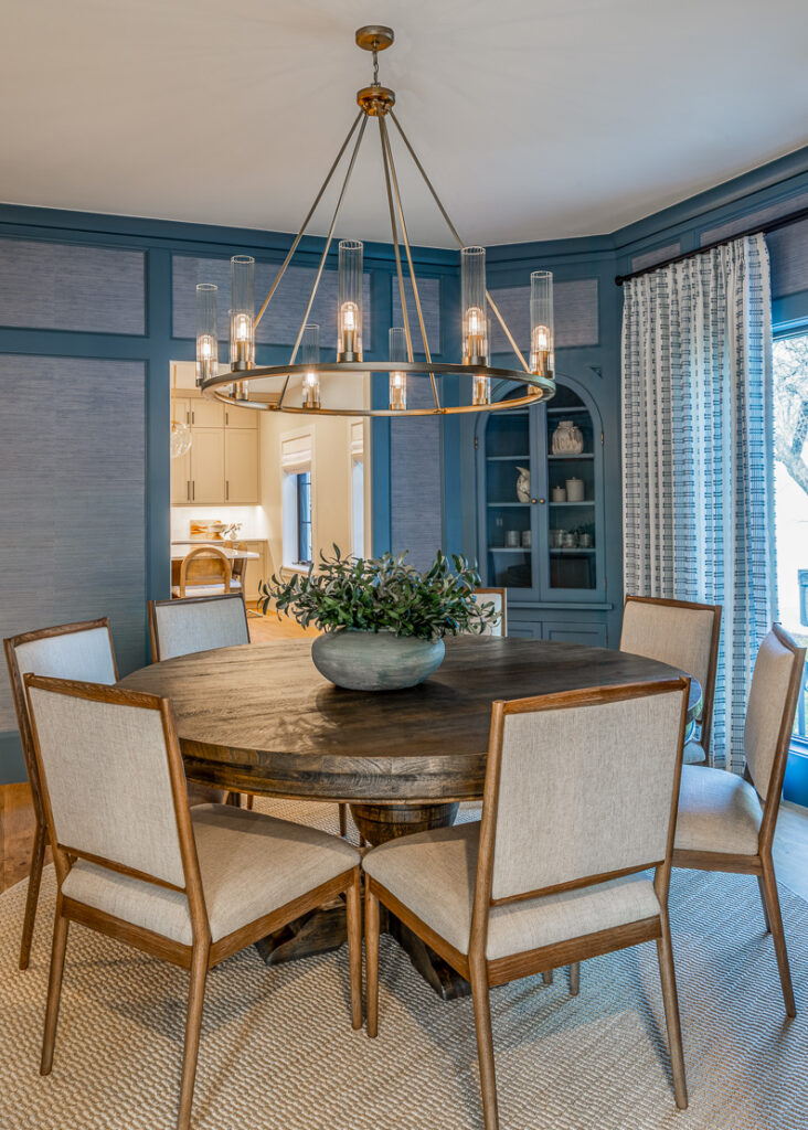 Color-drenched dining room with grasscloth wallpaper, statement chandelier, and restored millwork in Park Hill Denver remodel by Denver Design Group