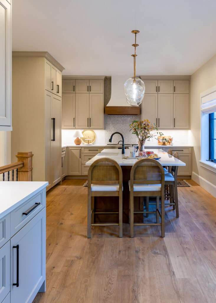 Custom kitchen remodel in 1917 Park Hill Denver home with island, range hood, and cane barstools by Denver Design Group
