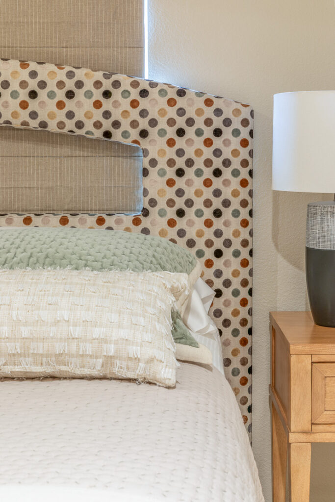 Guest bedroom with circle pattern headboard and navy lamp Lone Tree Colorado