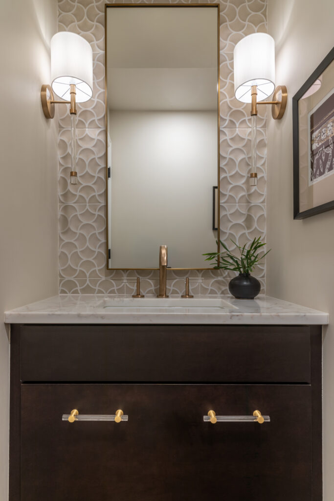 Bathroom vanity with brass sconces and dark cabinetry full home remodel Greenwood Village Colorado Denver Design Group