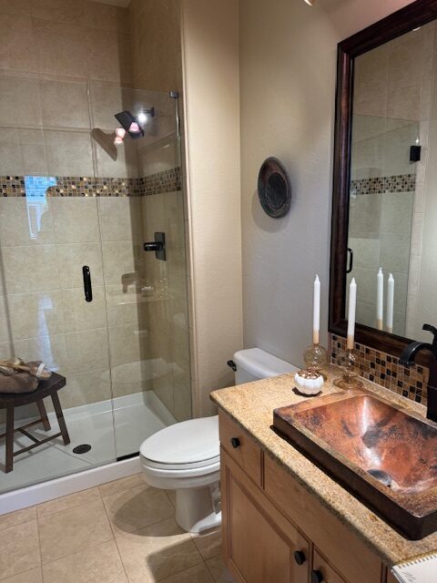 Dated main floor bathroom before remodel with builder-grade tile and dark mirror Littleton Colorado