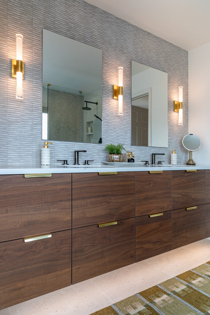 Walnut floating vanity detail with brass hardware and Visual Comfort sconces primary suite Littleton Colorado Denver Design Group
