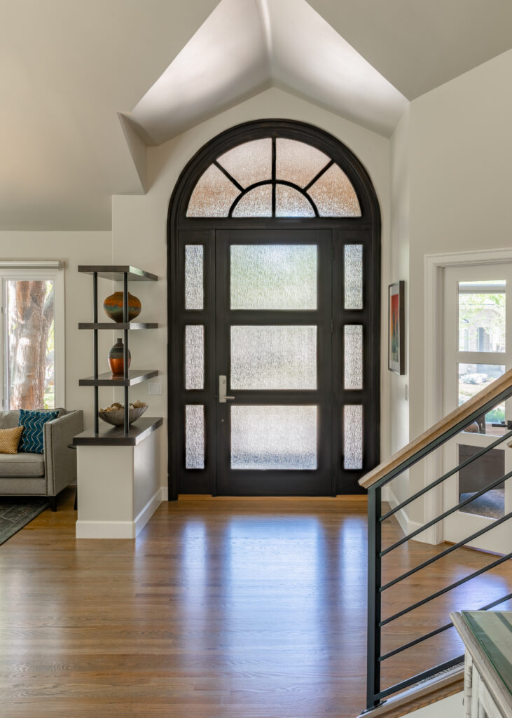 Entryway with modern horizontal stair railing and arched window full home remodel Greenwood Village Colorado Denver Design Group