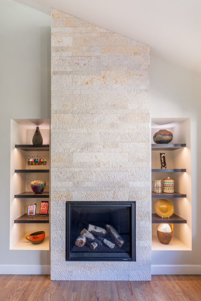 Family room fireplace remodel with Wave stone veneer surround and custom built-in shelving Greenwood Village Colorado Denver Design Group