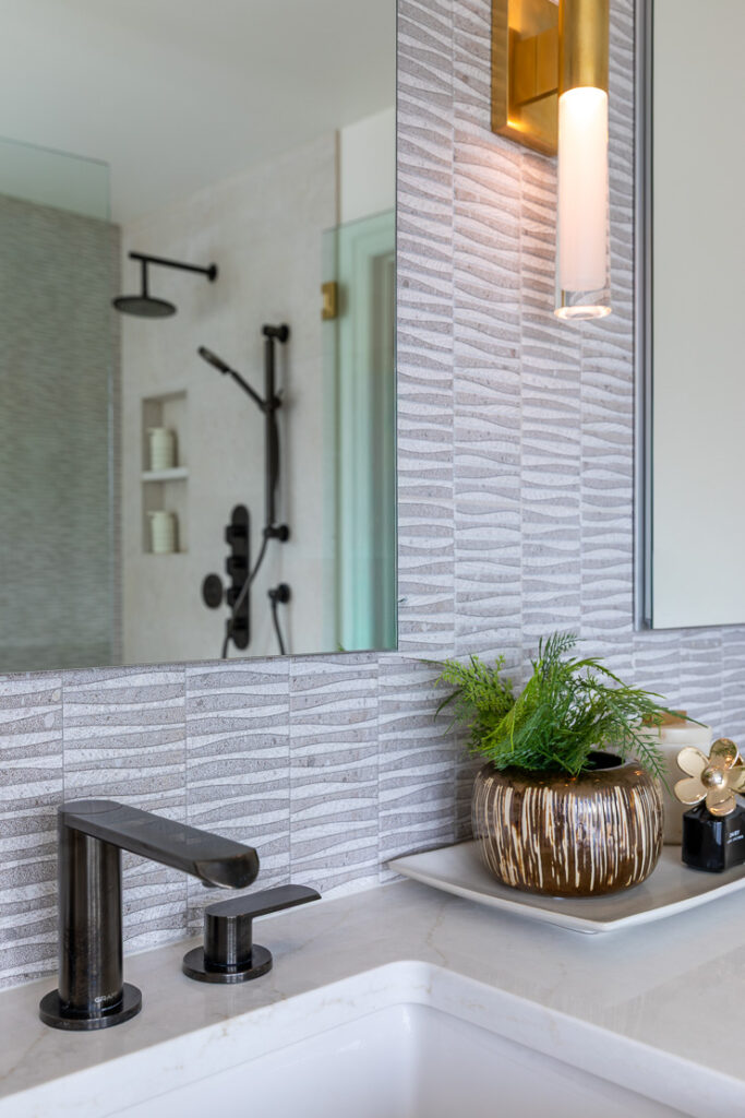 Graff onyx faucet and Visual Comfort sconce with accent tile detail primary bathroom remodel Littleton Colorado Denver Design Group