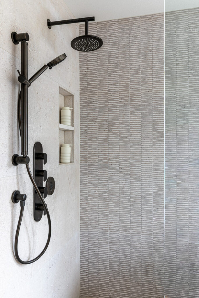 Frameless glass shower with Graff onyx fixtures and Porcelanosa tile primary bathroom remodel Littleton Colorado