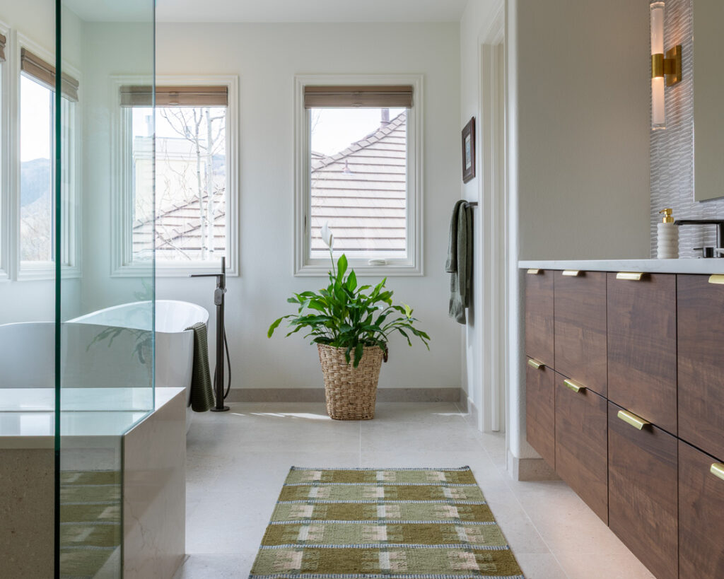 Transitional primary bathroom remodel with Porcelanosa tile freestanding tub and custom walnut vanity Littleton Colorado Denver Design Group